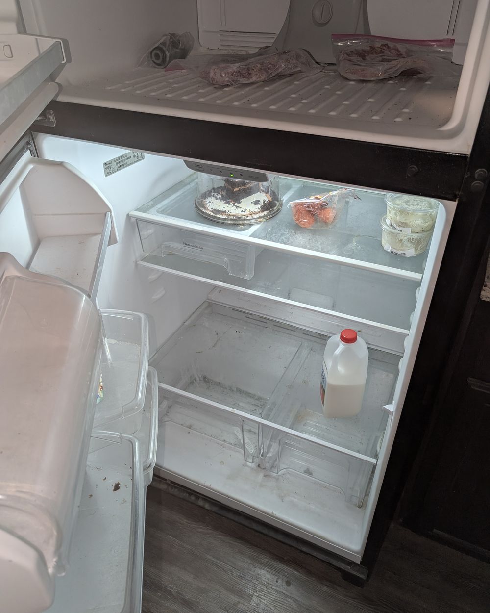 Refrigerator before cleaning — food residue and debris left behind