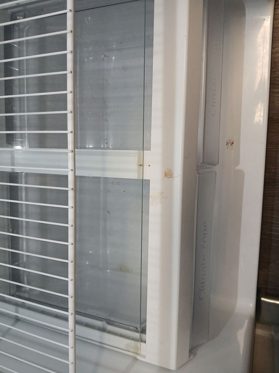 Refrigerator before cleaning — shelves and bins left dirty