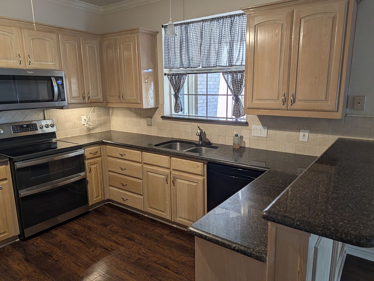 Kitchen after cleaning — cabinets, counters, and appliances ready to show