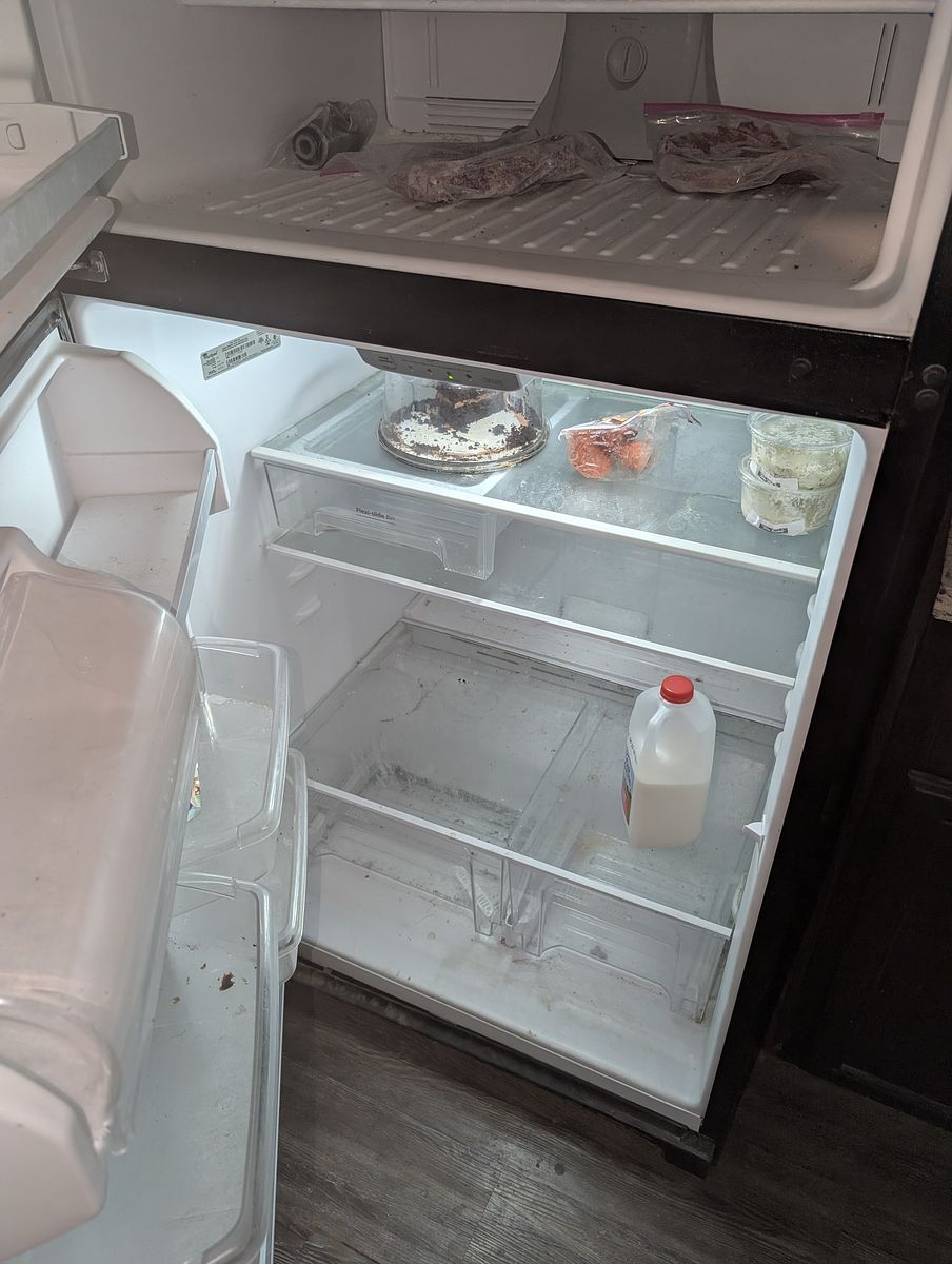 Refrigerator before cleaning — food residue and debris left behind
